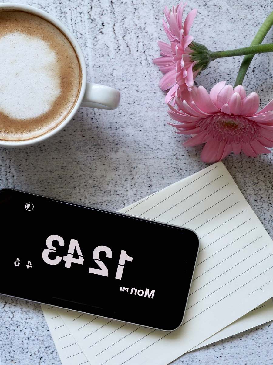 coffee cup black smartphone displaying 12:43 cup